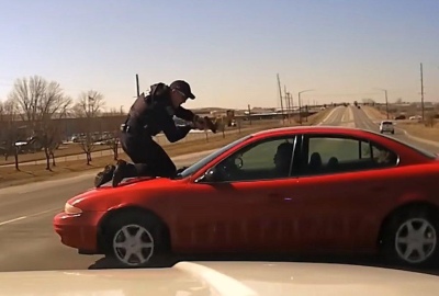 Un polic&iacute;a se par&oacute; en el cap&oacute; del auto para agarrar al delincuente